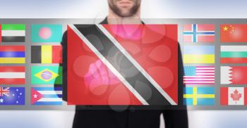 Hand pushing on a touch screen interface, choosing language or country, Trinidad and Tobago
