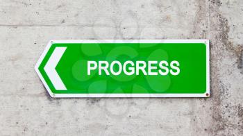 Green sign on a concrete wall - Progress