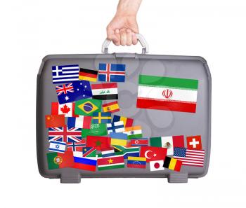 Used plastic suitcase with lots of small stickers, large sticker of Iran