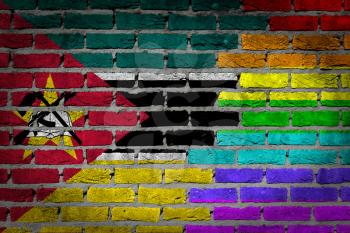 Dark brick wall texture - coutry flag and rainbow flag painted on wall - Mozambique