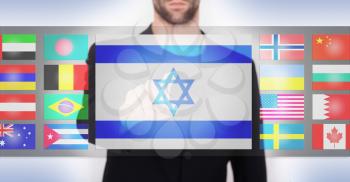 Hand pushing on a touch screen interface, choosing language or country, Israel