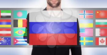 Hand pushing on a touch screen interface, choosing language or country, Russia