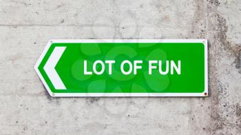 Green sign on a concrete wall - Lot of fun