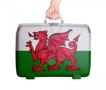 Used plastic suitcase with stains and scratches, printed with flag, Wales
