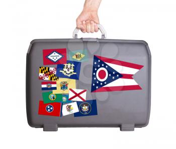Used plastic suitcase with stains and scratches, stickers of US States, Ohio