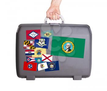 Used plastic suitcase with stains and scratches, stickers of US States, Washington