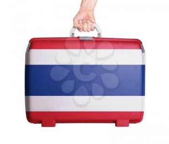 Used plastic suitcase with stains and scratches, printed with flag, Thailand