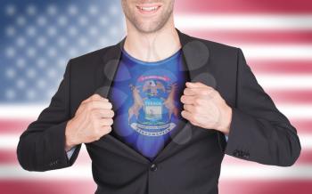 Businessman opening suit to reveal shirt with state flag (USA), Michigan