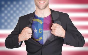 Businessman opening suit to reveal shirt with state flag (USA), North Carolina