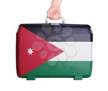 Used plastic suitcase with stains and scratches, printed with flag, Jordan