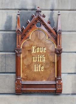 Decorative wooden sign hanging on a concrete wall - Love with life