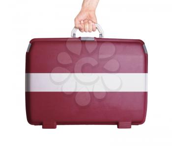 Used plastic suitcase with stains and scratches, printed with flag, Latvia
