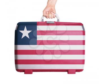 Used plastic suitcase with stains and scratches, printed with flag, Liberia