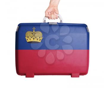 Used plastic suitcase with stains and scratches, printed with flag, Liechtenstein