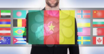 Hand pushing on a touch screen interface, choosing language or country, Cameroon