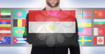 Hand pushing on a touch screen interface, choosing language or country, Egypt