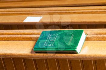 Good News Bible on a wooden church bench