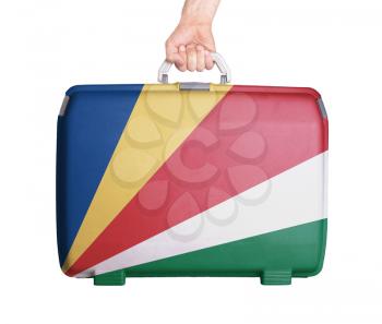 Used plastic suitcase with stains and scratches, printed with flag, Seychelles