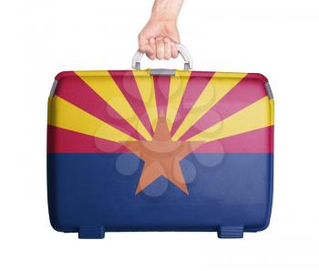 Used plastic suitcase with stains and scratches, printed with flag, Arizona