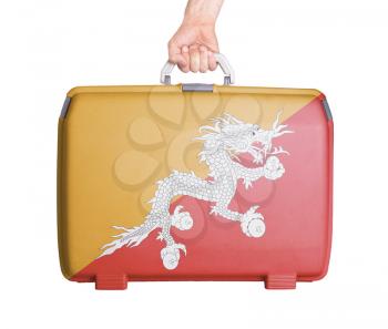 Used plastic suitcase with stains and scratches, printed with flag, Bhutan