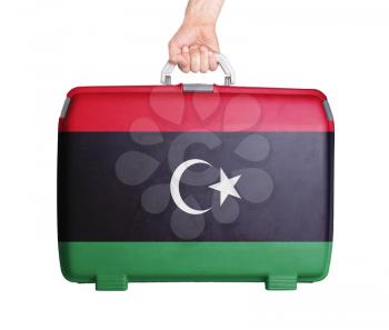 Used plastic suitcase with stains and scratches, printed with flag, Libya