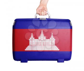 Used plastic suitcase with stains and scratches, printed with flag, Cambodia