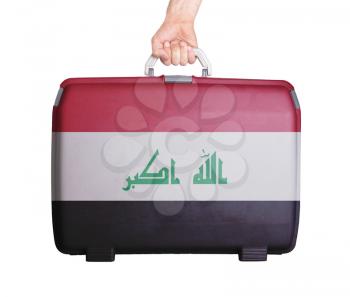 Used plastic suitcase with stains and scratches, printed with flag, Iraq