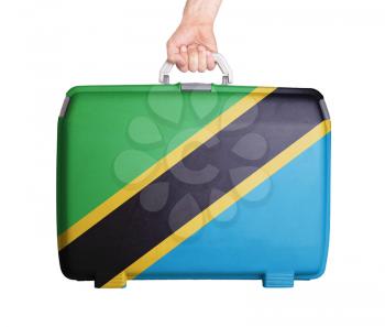 Used plastic suitcase with stains and scratches, printed with flag, Tanzania