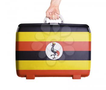 Used plastic suitcase with stains and scratches, printed with flag, Uganda