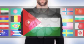 Hand pushing on a touch screen interface, choosing language or country, Jordan
