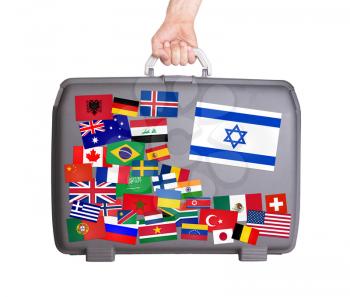 Used plastic suitcase with lots of small stickers, large sticker of Israel