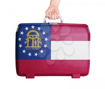 Used plastic suitcase with stains and scratches, printed with flag, Georgia