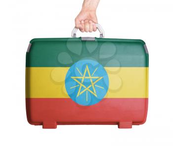 Used plastic suitcase with stains and scratches, printed with flag, Ethiopia