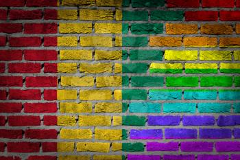 Dark brick wall texture - coutry flag and rainbow flag painted on wall - Guinea