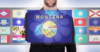 Hand pushing on a touch screen interface, choosing a state, Montana