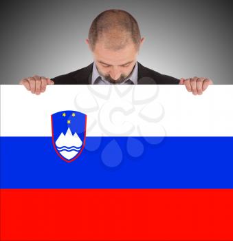 Businessman holding a big card, flag of Slovenia, isolated on white
