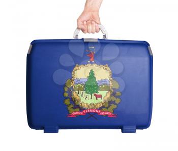 Used plastic suitcase with stains and scratches, printed with flag, Vermont