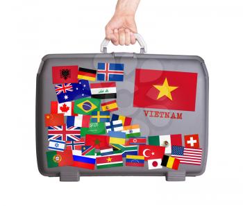 Used plastic suitcase with lots of small stickers, large sticker of Vietnam