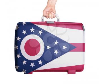 Used plastic suitcase with stains and scratches, printed with flag, Ohio