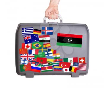 Used plastic suitcase with lots of small stickers, large sticker of, Libya