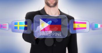 Hand pushing on a touch screen interface, choosing language or country, Philippines