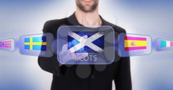 Hand pushing on a touch screen interface, choosing language or country, Scotland