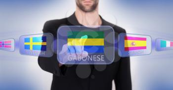 Hand pushing on a touch screen interface, choosing language or country, Gabonese