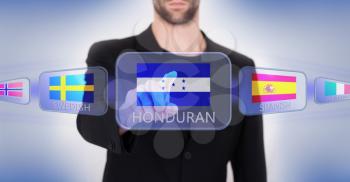 Hand pushing on a touch screen interface, choosing language or country, Honduras