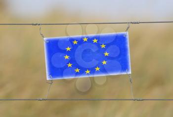 Border fence - Old plastic sign with a flag - European Union