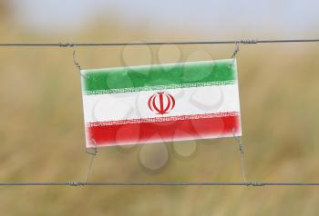 Border fence - Old plastic sign with a flag - Iran