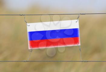 Border fence - Old plastic sign with a flag - Russia