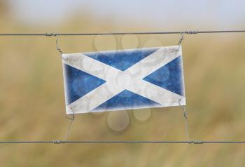 Border fence - Old plastic sign with a flag - Scotland