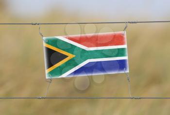 Border fence - Old plastic sign with a flag - South Africa