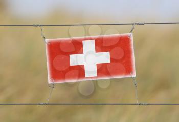 Border fence - Old plastic sign with a flag - Switzerland